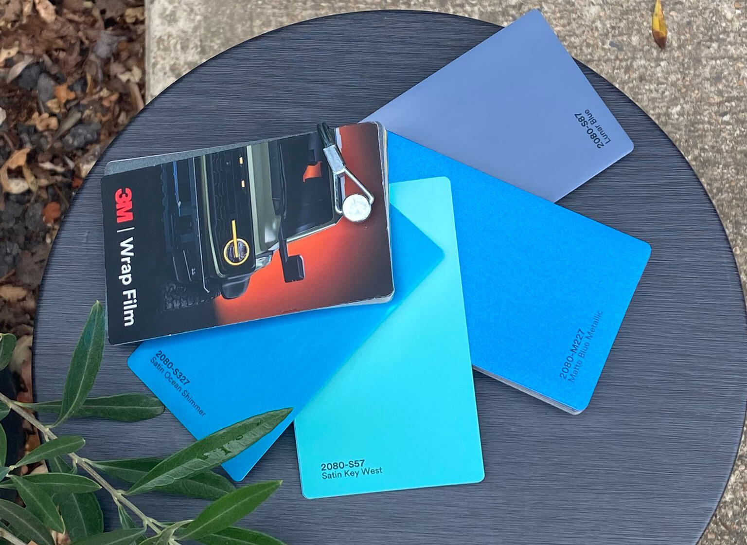 Three colored notebooks arranged on a table, showcasing vibrant hues of blue, red, and green.