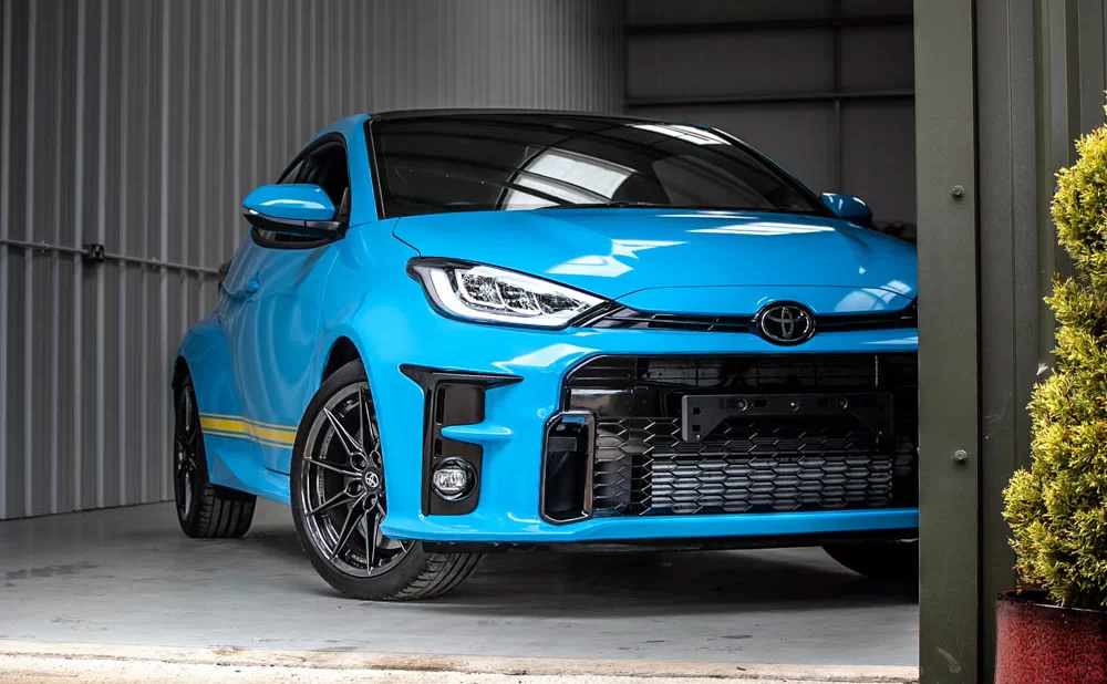 A Toyota Yaris parked inside a garage, showcasing its compact design and modern features.