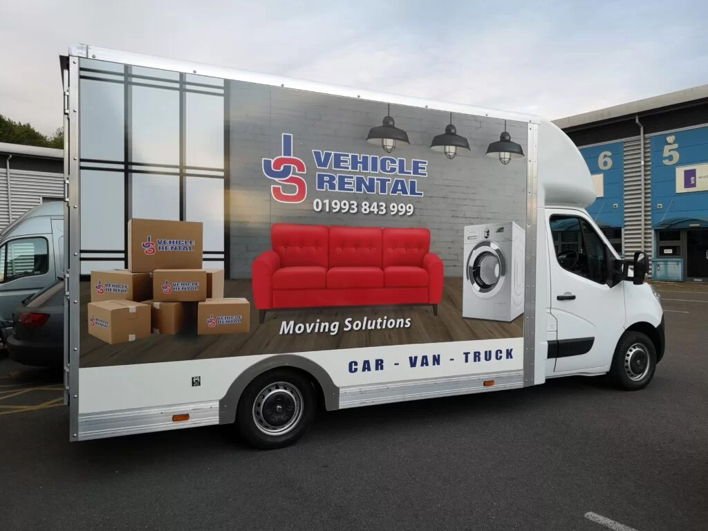 A moving truck loaded with a couch and various pieces of furniture ready for transport.