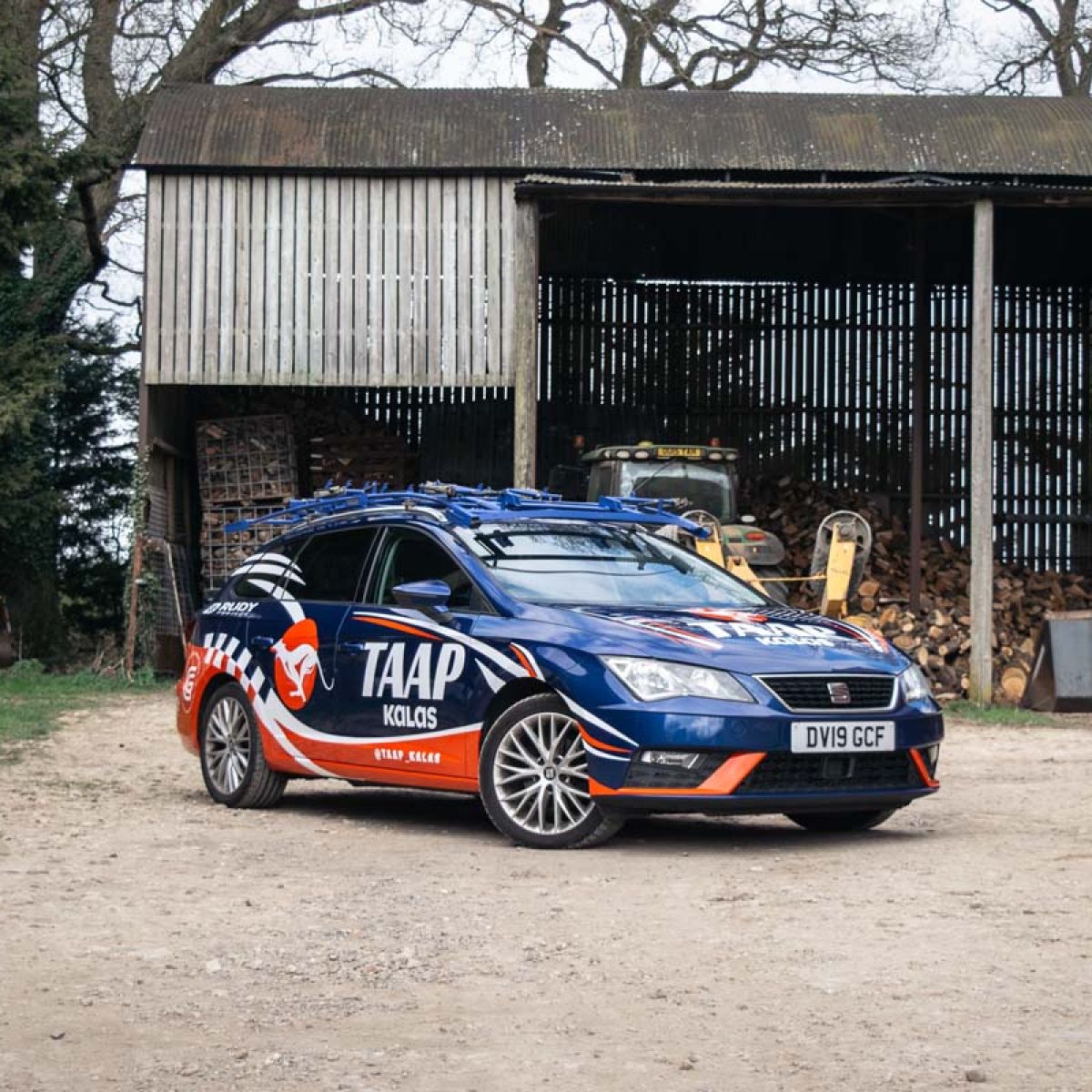 TAAP Kalas branded SEAT estate car parked in front of a rural barn.