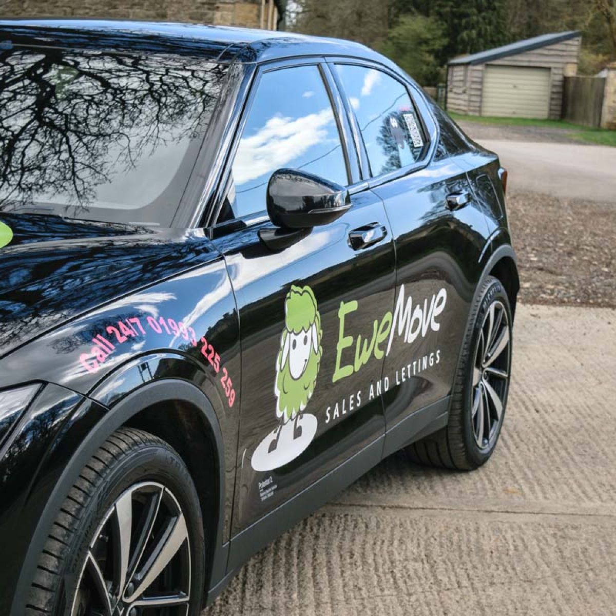 EweMove branded black electric SUV with estate agency graphics parked outdoors.