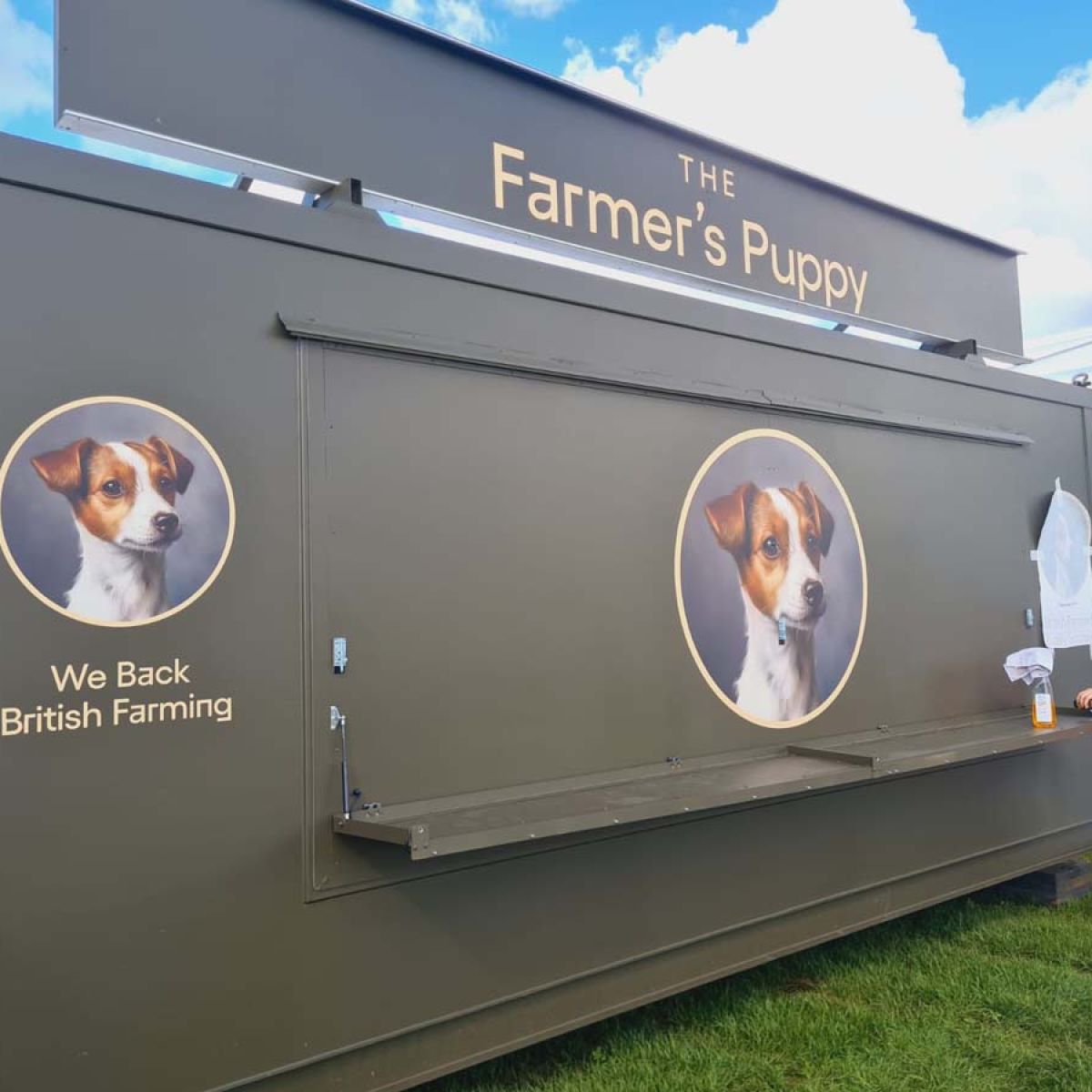 The Farmer's Puppy food kiosk wrapped with branded graphics at an outdoor event.