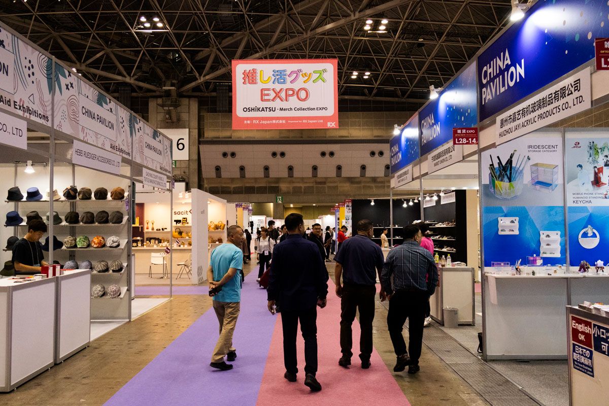 A bustling convention hall filled with people exploring various booths and engaging in conversations.