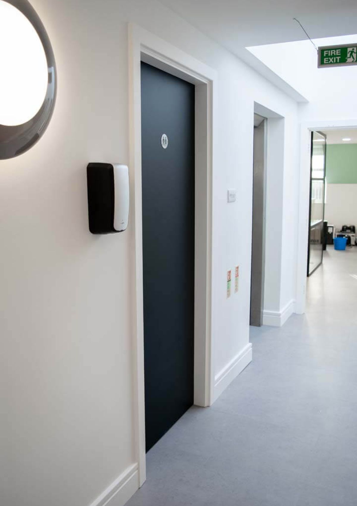 A black toilet room door in a white hallway